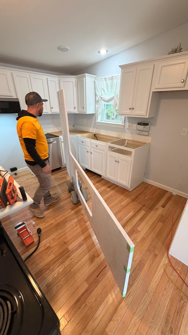 ECR installer carrying a countertop slab into a New England kitchen during installation